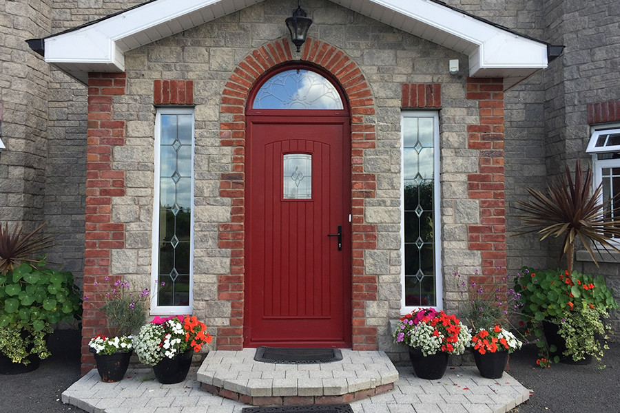 a red composite door on a face brick house