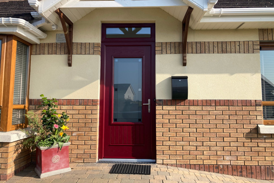 a red single composite door on a brick house
